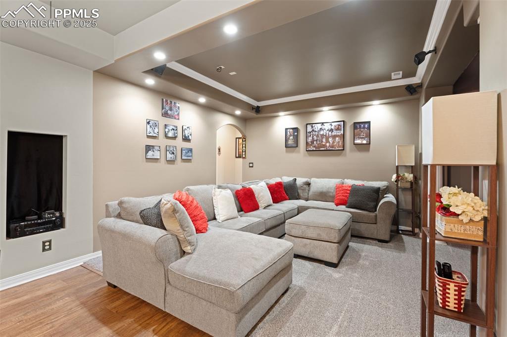 Image 25 of 41: Living room with arched walkways, a raised ceiling, recessed lighting, ligh