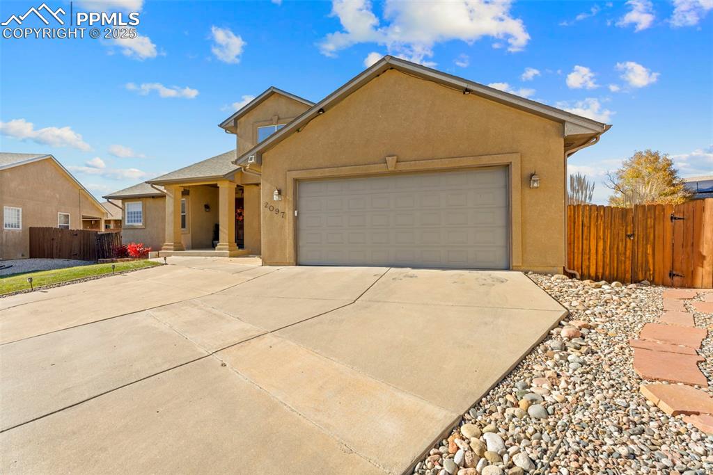 Image 3 of 41: View of front of property featuring stucco siding, concrete driveway, a gar
