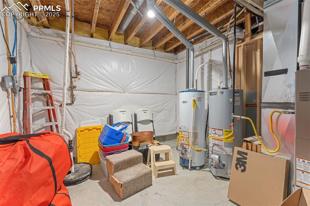 Image 30 of 41: Unfinished basement with gas water heater and heating unit