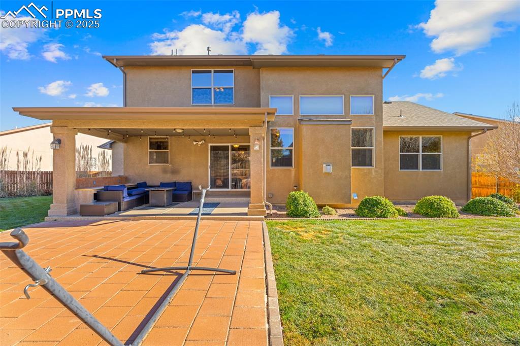 Image 31 of 41: Back of property featuring an outdoor hangout area, stucco siding, and a pa
