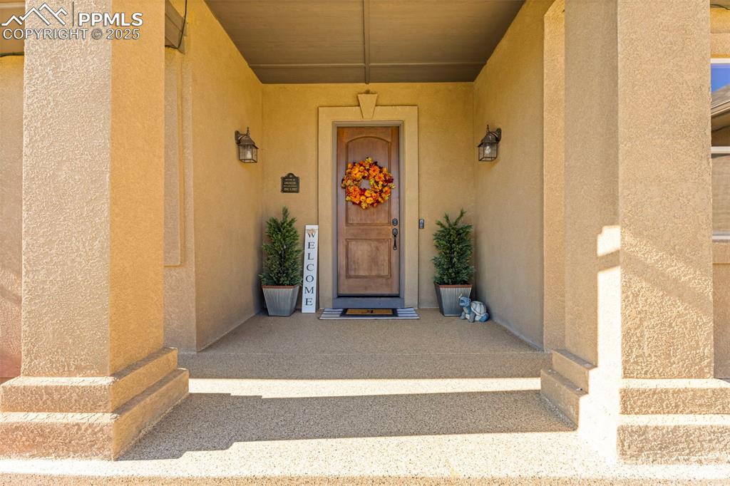 Image 4 of 41: Doorway to property with stucco siding and covered porch