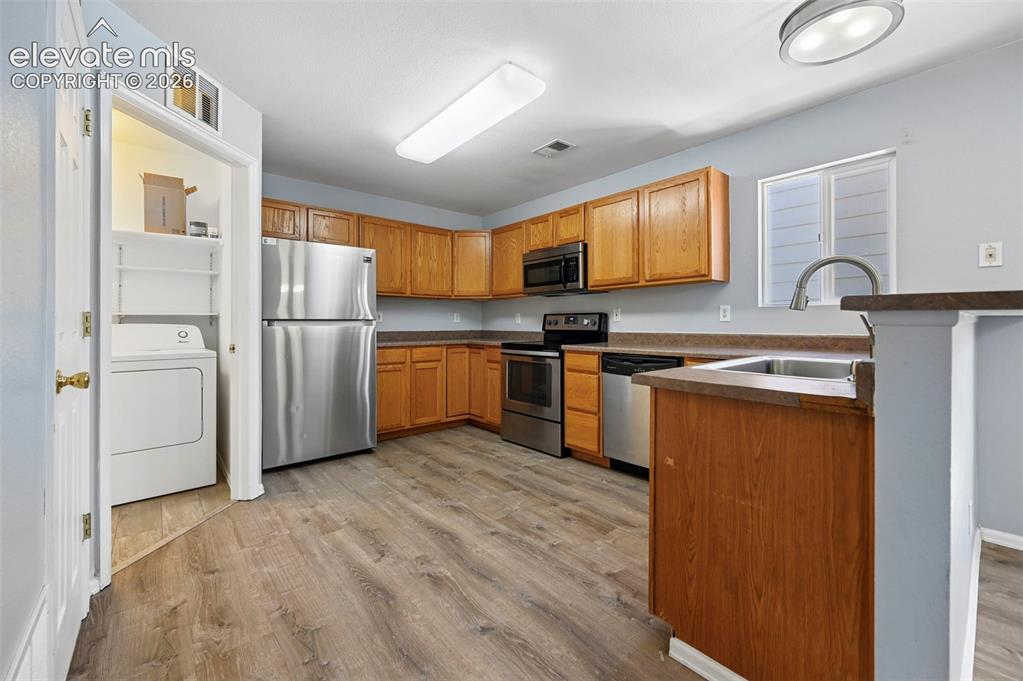 Image 14 of 27: Kitchen featuring wood-finish cabinetry, stainless steel appliances, wood-f
