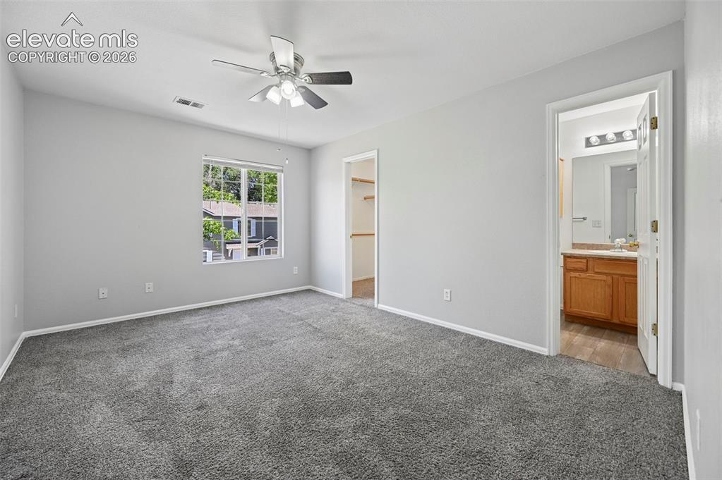 Image 18 of 27: Spacious room featuring gray wall paint, gray carpeting, a window with whit