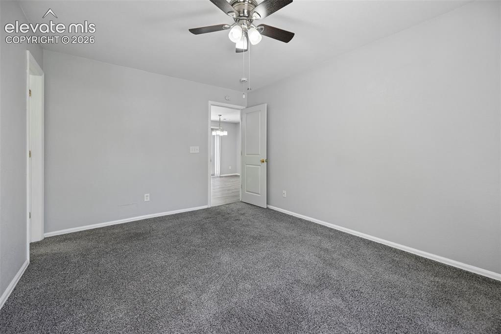 Image 19 of 27: Spacious room featuring gray wall paint, gray carpet flooring, white basebo