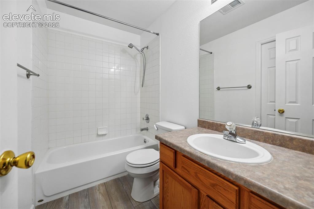 Image 20 of 27: Bathroom featuring a full tub with white subway tile surround, wood-finish