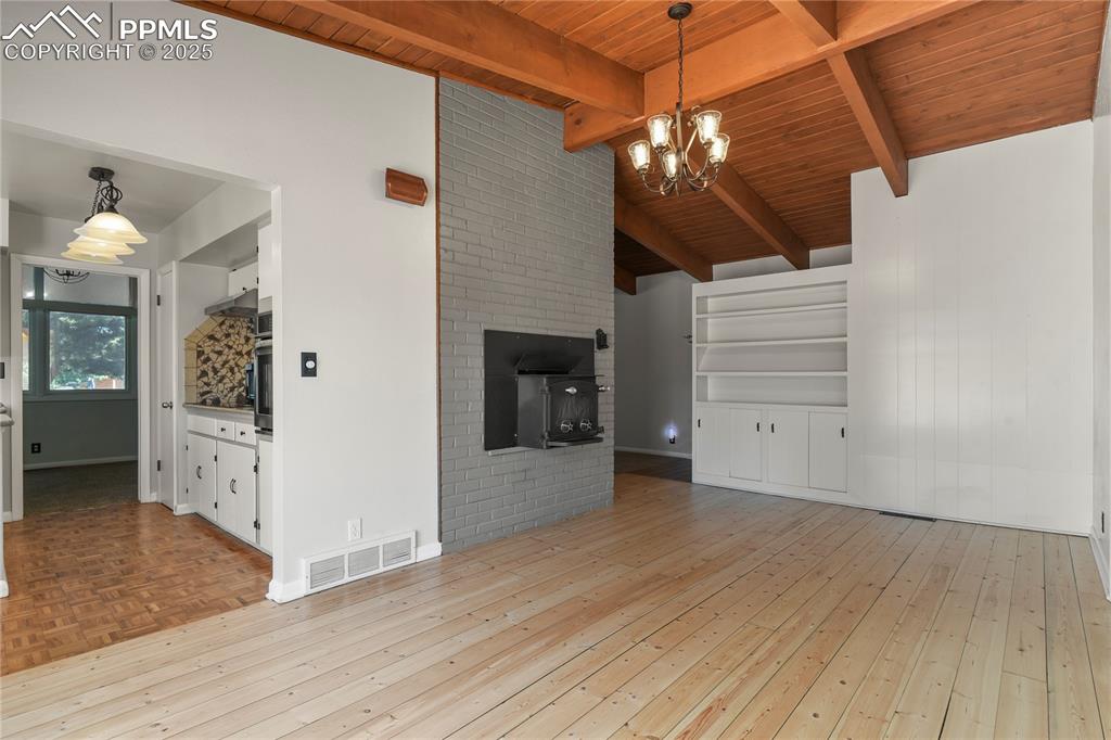 Image 16 of 38: With hardwood floors and wood stove