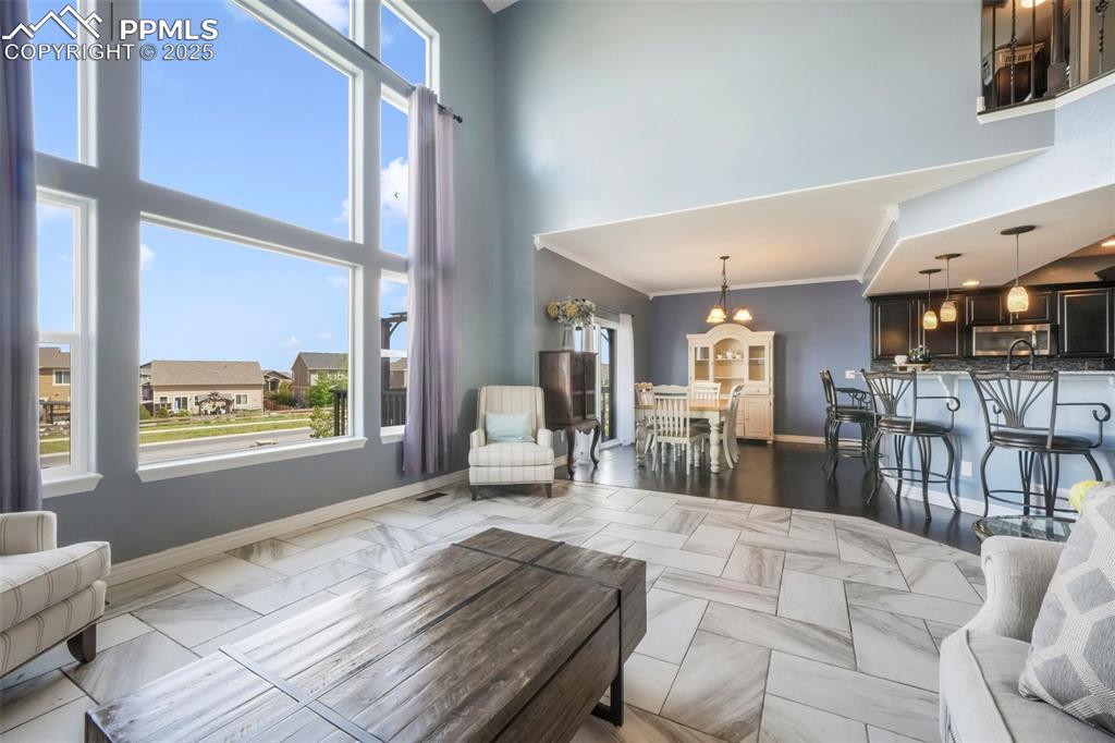 Image 17 of 50: Main level living room with fireplace, large windows and access to upper de