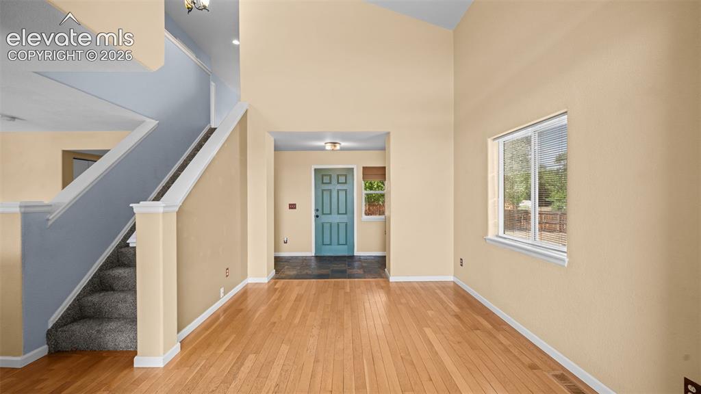 Image 8 of 50: Wide entry area with closet space and opening in to two-story living area