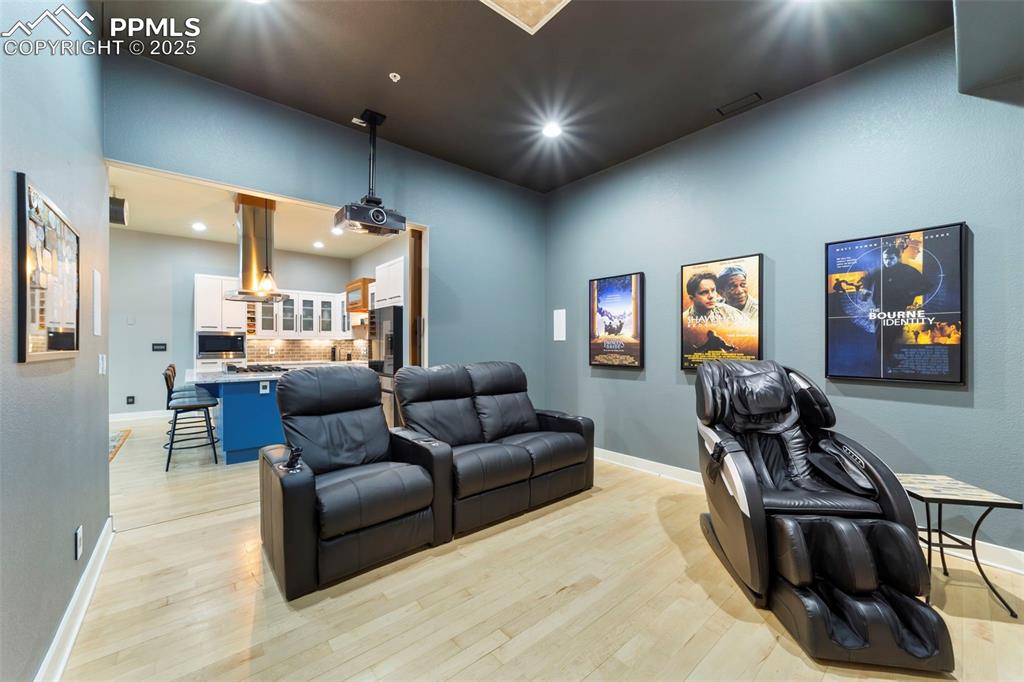 Image 16 of 40: Theater room with hardwood floors and recessed lighting