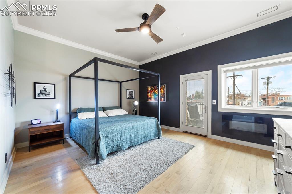 Image 17 of 40: Primary Bedroom with crown molding, hardwood floors, ceiling fan, and acces