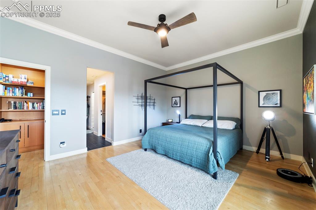Image 18 of 40: Primary Bedroom with crown molding, hardwood floors, ceiling fan, and acces