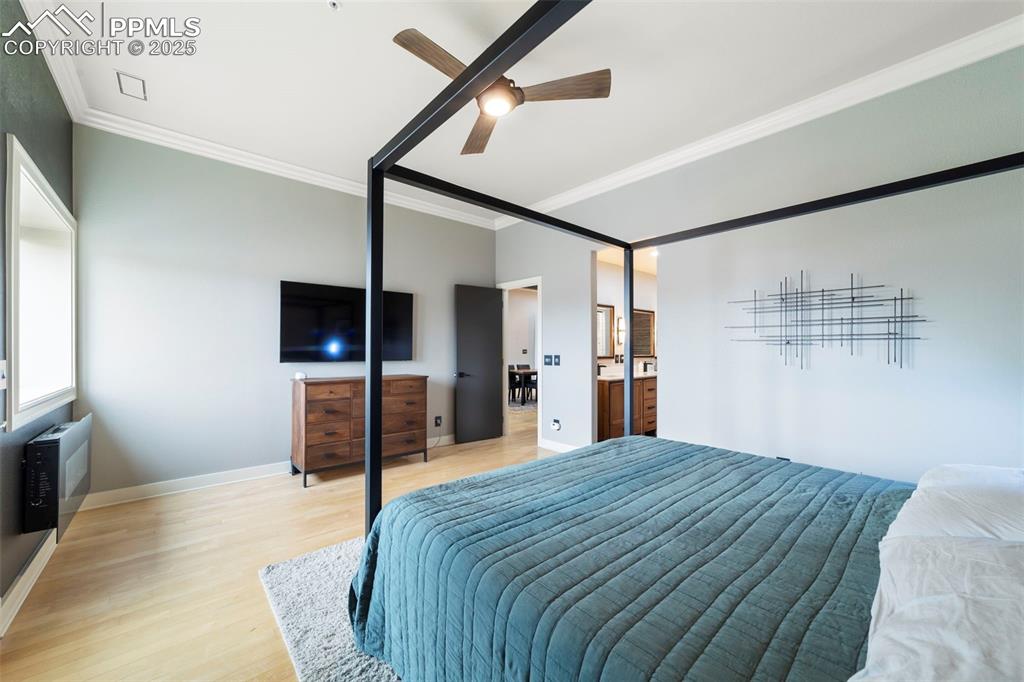 Image 19 of 40: Primary Bedroom with crown molding, hardwood floors, ceiling fan, and acces