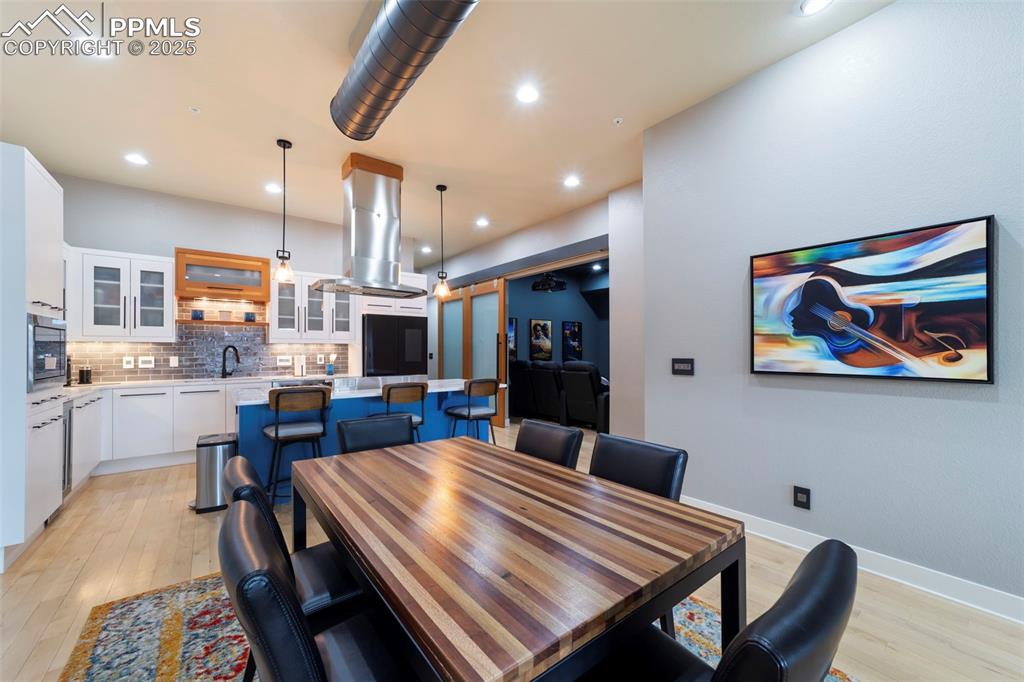 Image 2 of 40: Dining room with hardwood floors and recessed lighting