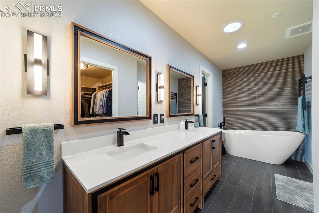 Image 20 of 40: Primary Full bath just renovated and featuring a spacious walk-in closet, a