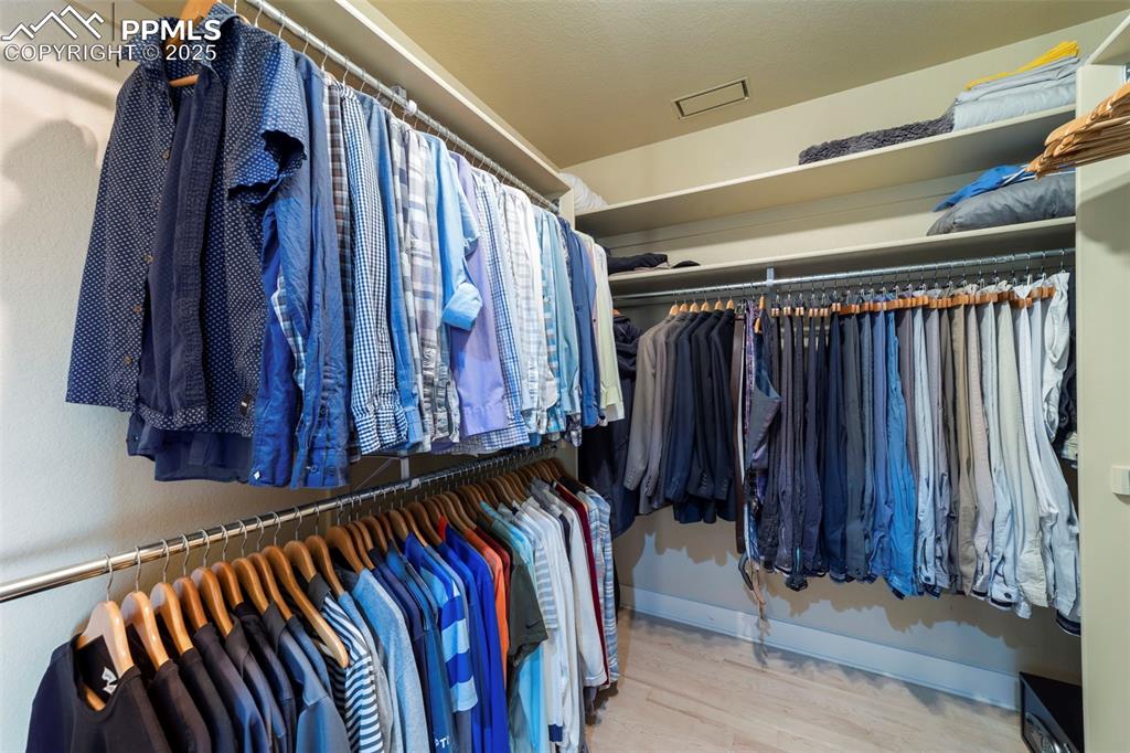 Image 23 of 40: Primary bedroom walk in closet featuring light wood-style floors
