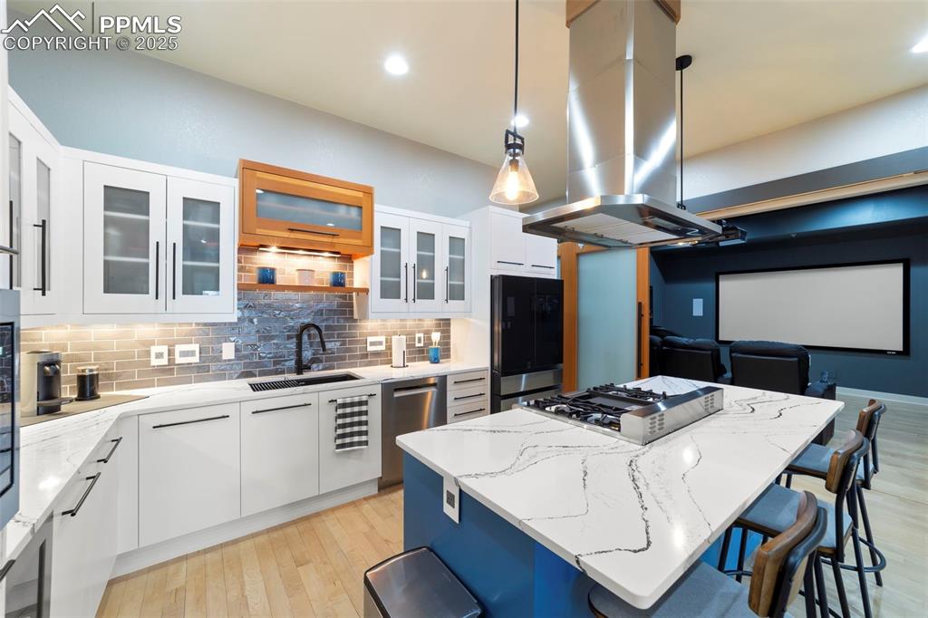 Image 3 of 40: Kitchen with white cabinetry, decorative light fixtures, a kitchen island, 