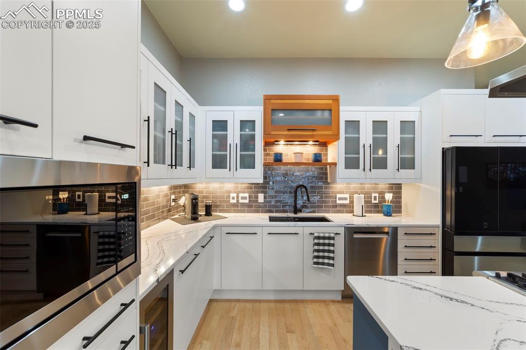 Image 7 of 40: Kitchen with white cabinets, backsplash, open shelves, quartz countertops, 