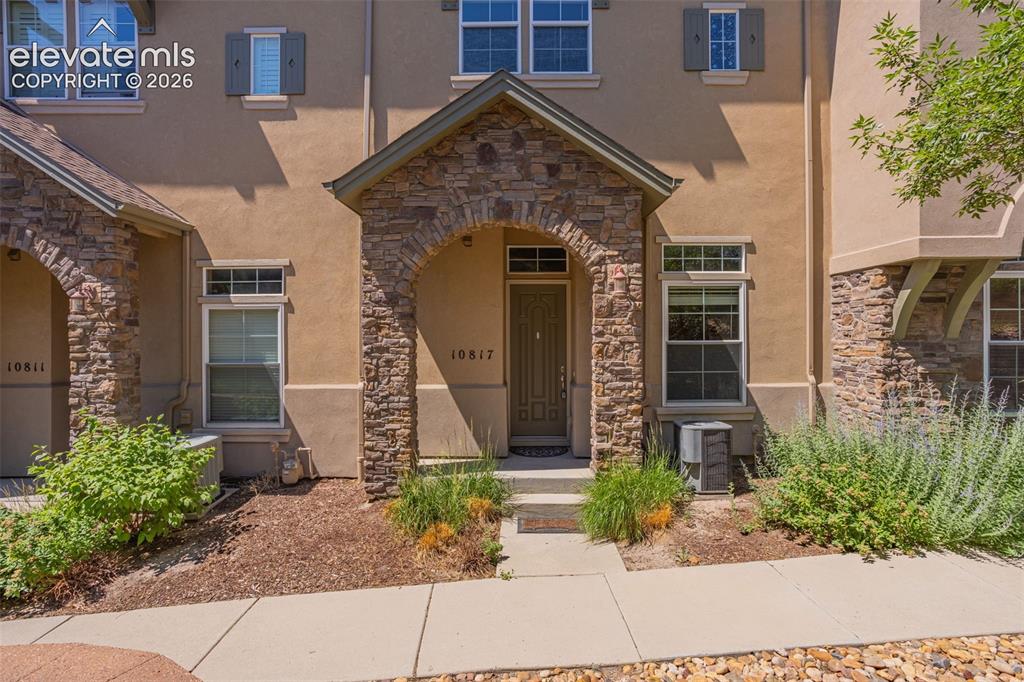 Caption: Stucco exterior with stone veneer accents and a covered entryway