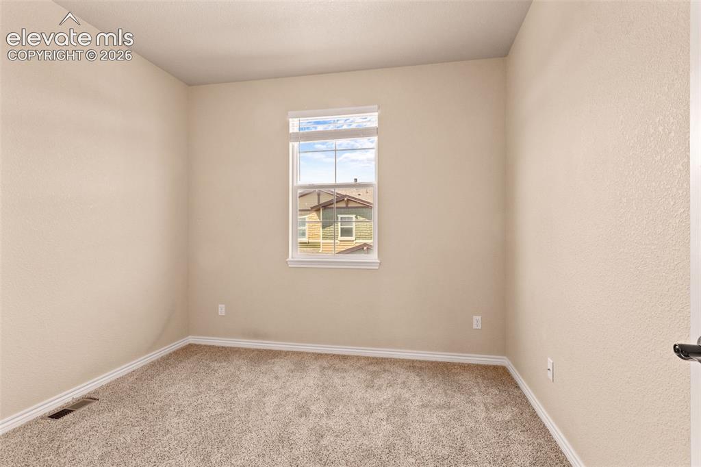 Image 12 of 26: Room featuring neutral-toned walls, white trim, and a window with white cas