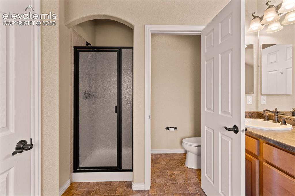 Image 15 of 26: Shower enclosure with dark bronze framing and frosted glass, complemented b