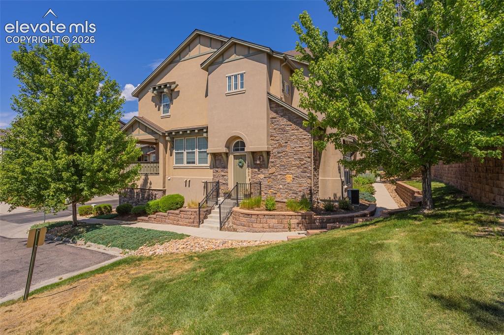 Image 18 of 26: Multi-level exterior featuring stone veneer and stucco siding