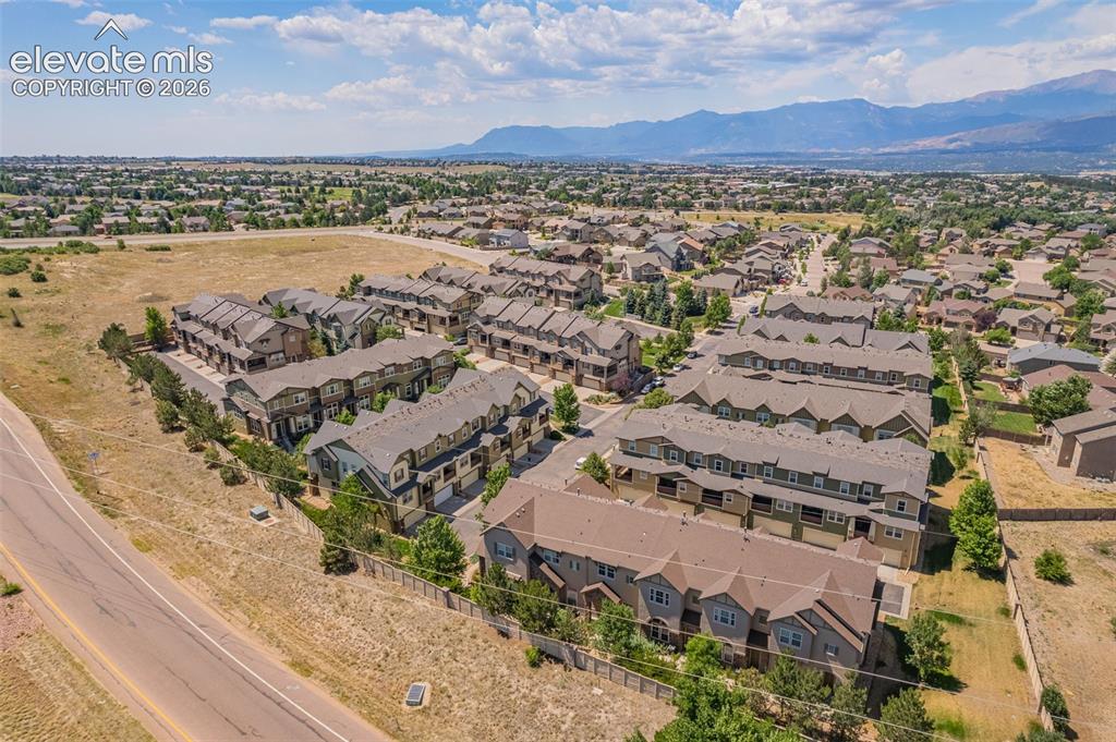 Image 23 of 26: Aerial perspective of a multi-unit residential development with a mountain 