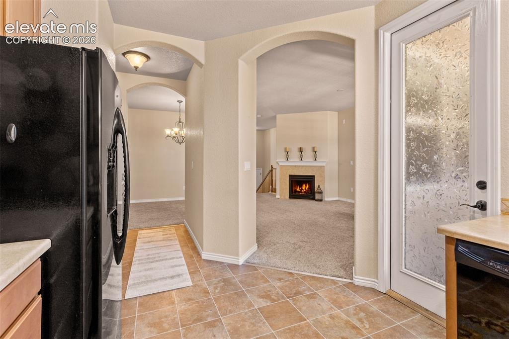 Image 5 of 26: Kitchen featuring tile flooring, light-toned countertops, and a white pantr