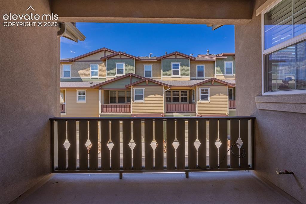 Image 6 of 26: Private balcony featuring a decorative wood railing, stucco exterior, and d