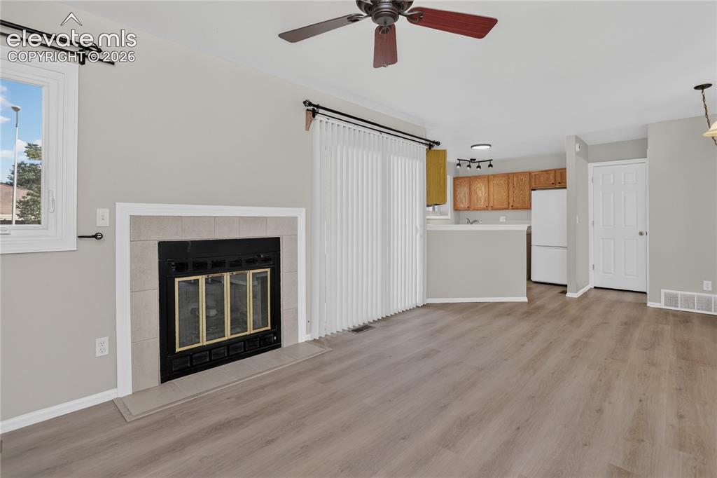 Image 10 of 44: Open-concept living area featuring wood-finish flooring, a ceiling fan with