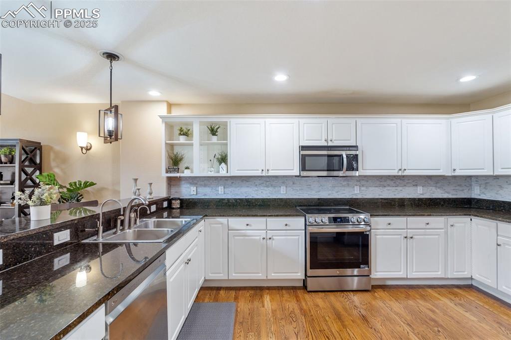 Image 10 of 50: Kitchen featuring white cabinets, appliances with stainless steel finishes,
