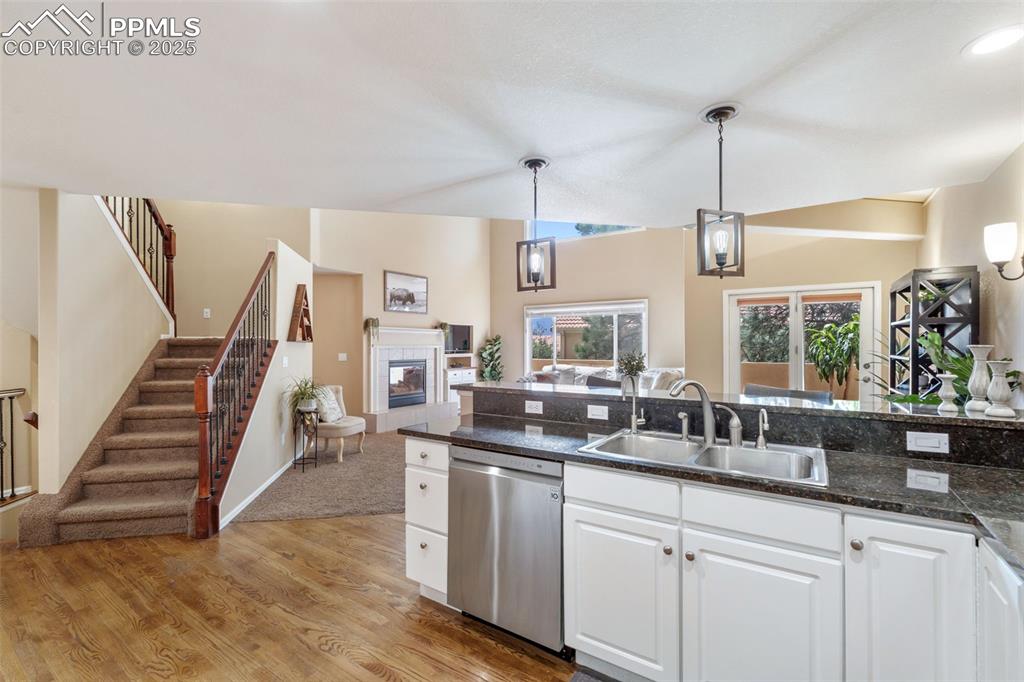 Image 11 of 50: Kitchen featuring light wood-style flooring, white cabinetry, hanging light