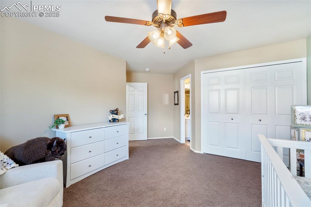 Image 22 of 50: Bedroom featuring carpet, a closet, a ceiling fan, and ensuite bathroom