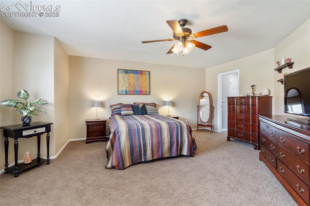 Image 23 of 50: Bedroom featuring light colored carpet and a ceiling fan