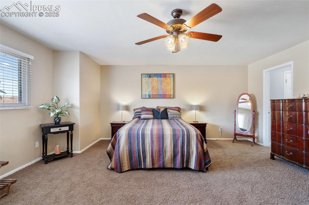 Image 24 of 50: Bedroom featuring light colored carpet and a ceiling fan