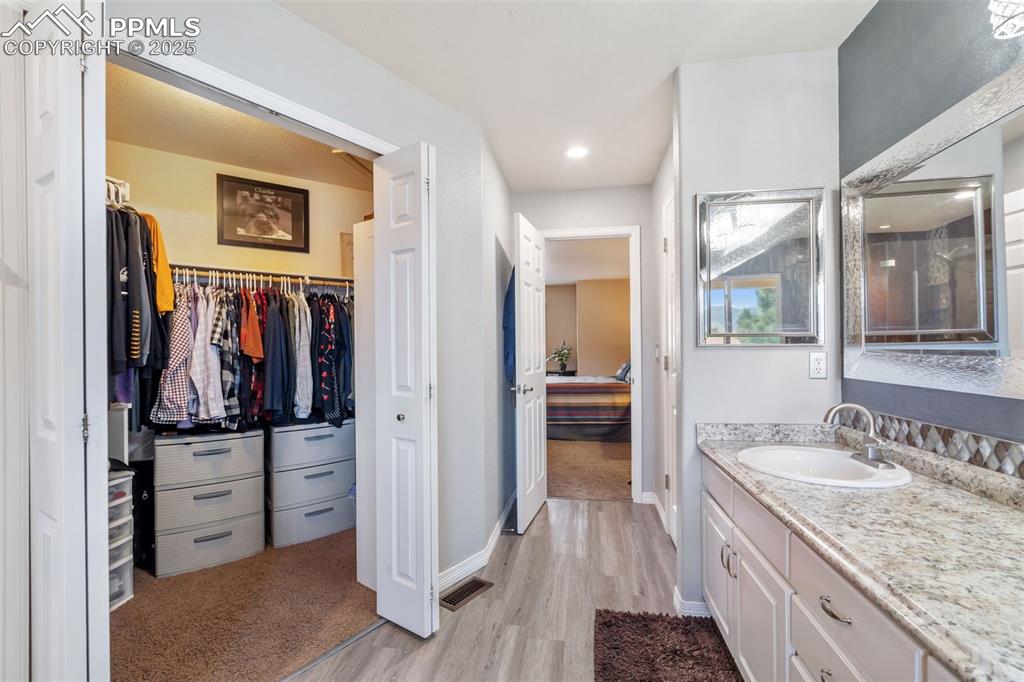 Image 28 of 50: Full bathroom featuring light wood-style flooring, vanity, and a spacious c