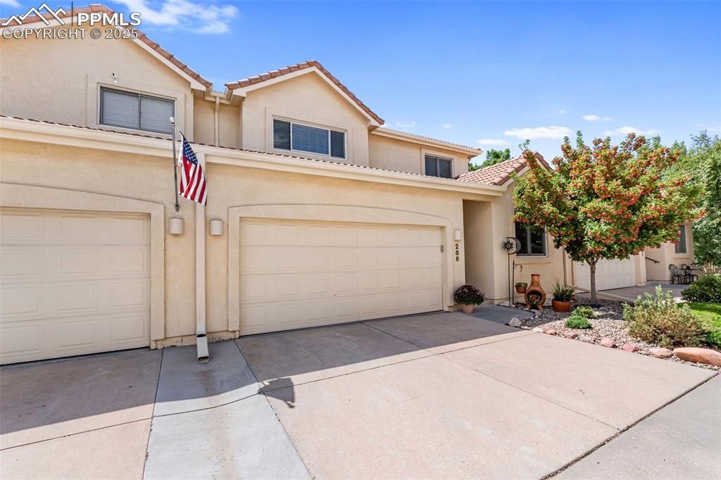 Image 3 of 50: Mediterranean / spanish home with concrete driveway, stucco siding, a tiled