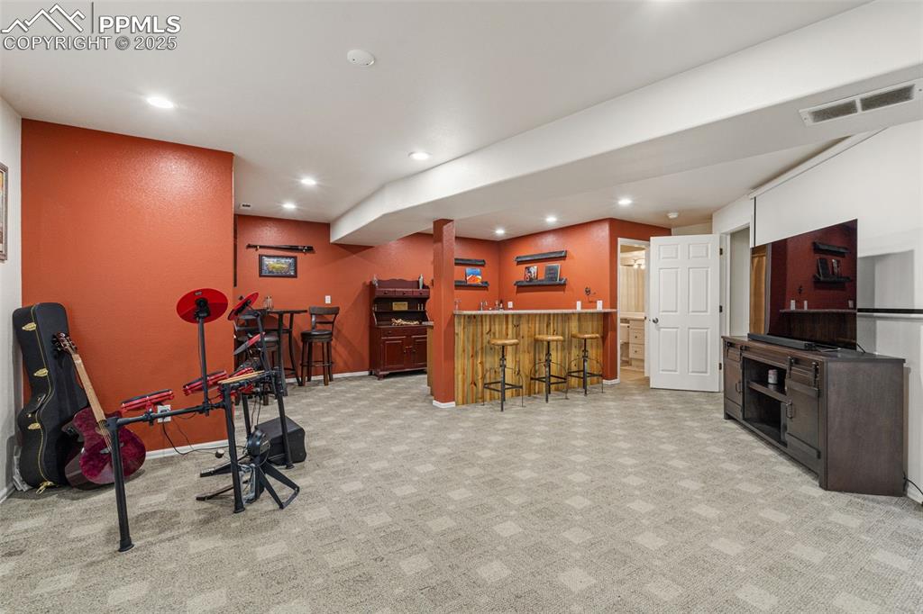 Image 36 of 50: Recreation room featuring recessed lighting, bar area, and light carpet