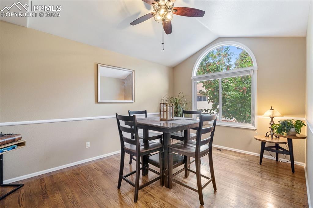 Image 4 of 50: Dining room with vaulted ceiling, light wood-style floors, and ceiling fan