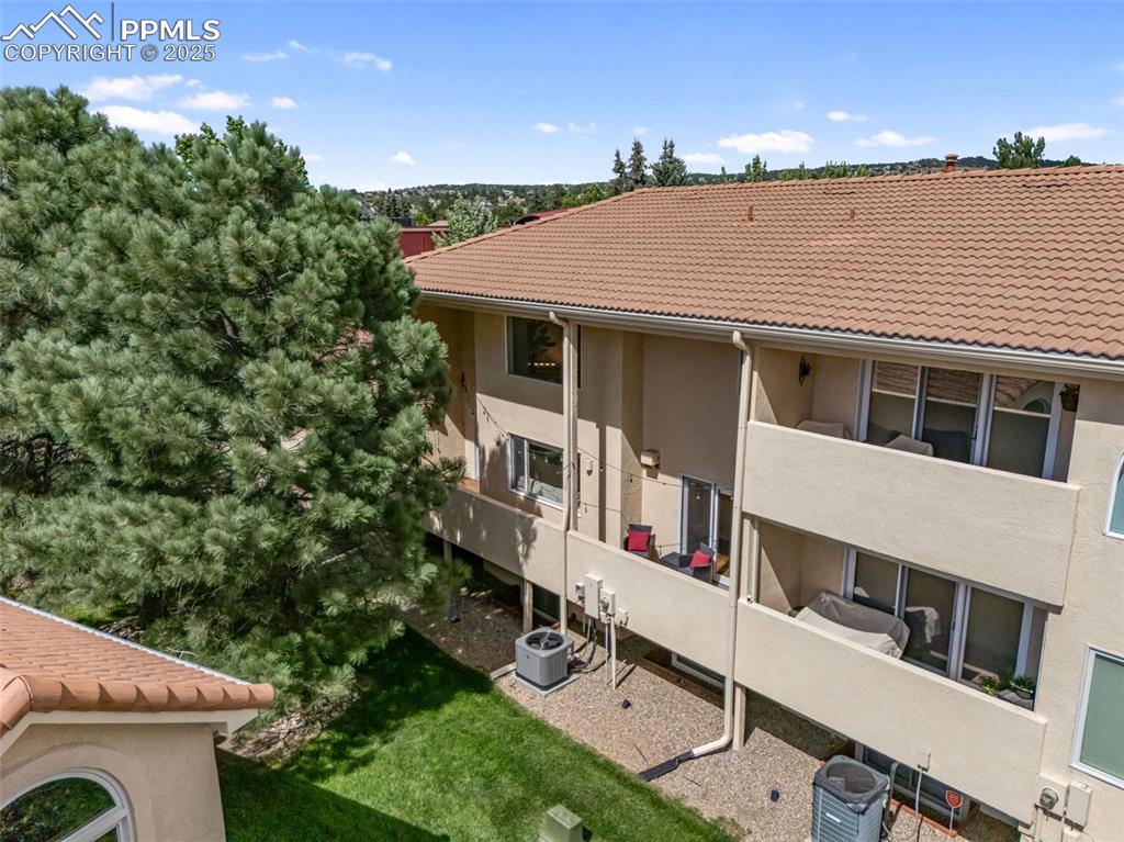 Image 44 of 50: Back of property featuring stucco siding, a tiled roof, and a balcony
