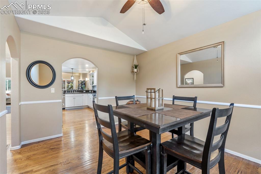 Image 5 of 50: Dining area featuring arched walkways, light wood-style flooring, ceiling f