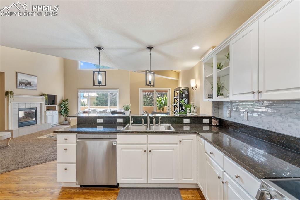 Image 8 of 50: Kitchen with open floor plan, a peninsula, white cabinets, stainless steel 