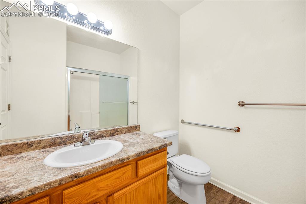 Image 10 of 37: Full bath featuring a shower stall, vanity, and dark wood-style flooring