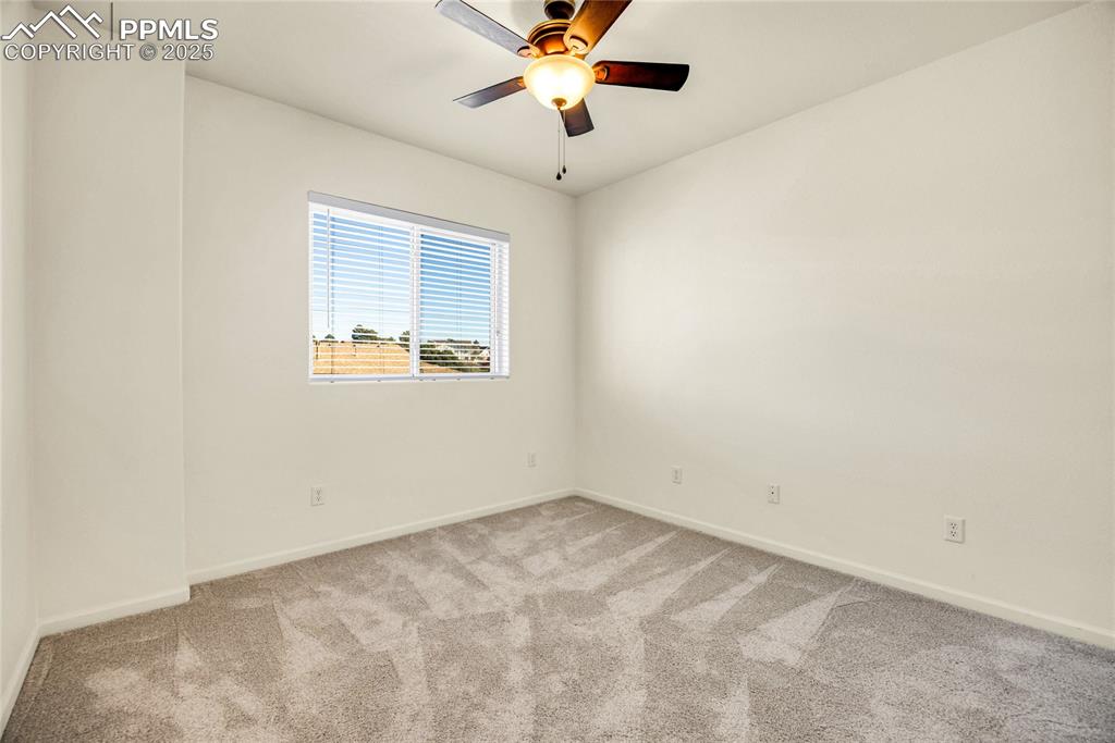 Image 21 of 37: Carpeted spare room with baseboards and a ceiling fan