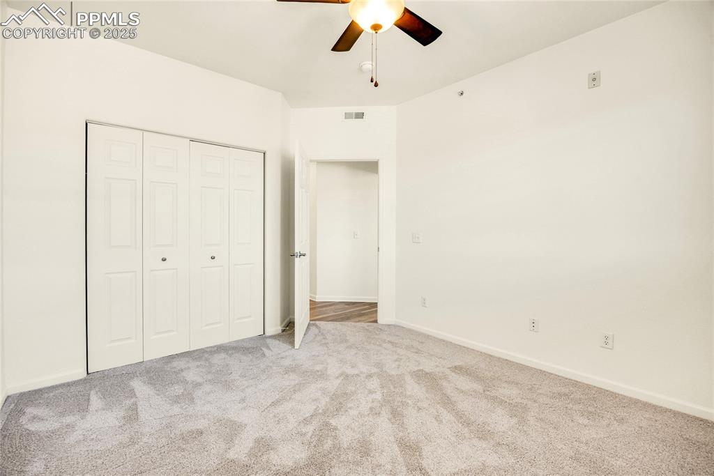 Image 22 of 37: Unfurnished bedroom with carpet flooring, ceiling fan, and a closet