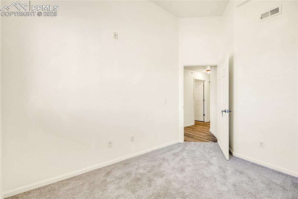 Image 24 of 37: Spare room with carpet flooring and a towering ceiling