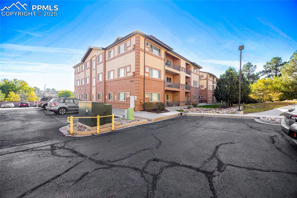 Image 3 of 37: View of apartment building / complex with uncovered parking
