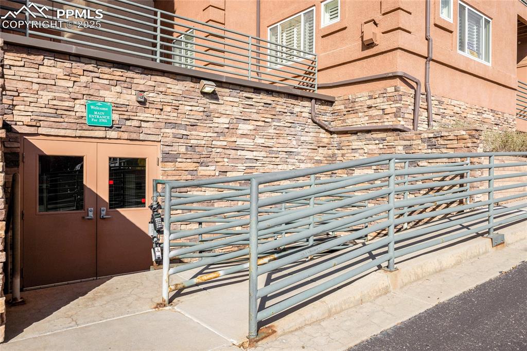 Image 32 of 37: Entrance to property with stone siding, stucco siding, and french doors