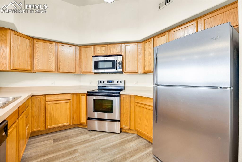 Image 5 of 37: Kitchen featuring appliances with stainless steel finishes, light counterto
