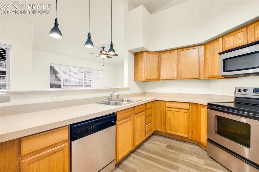 Image 7 of 37: Kitchen featuring appliances with stainless steel finishes, hanging light f