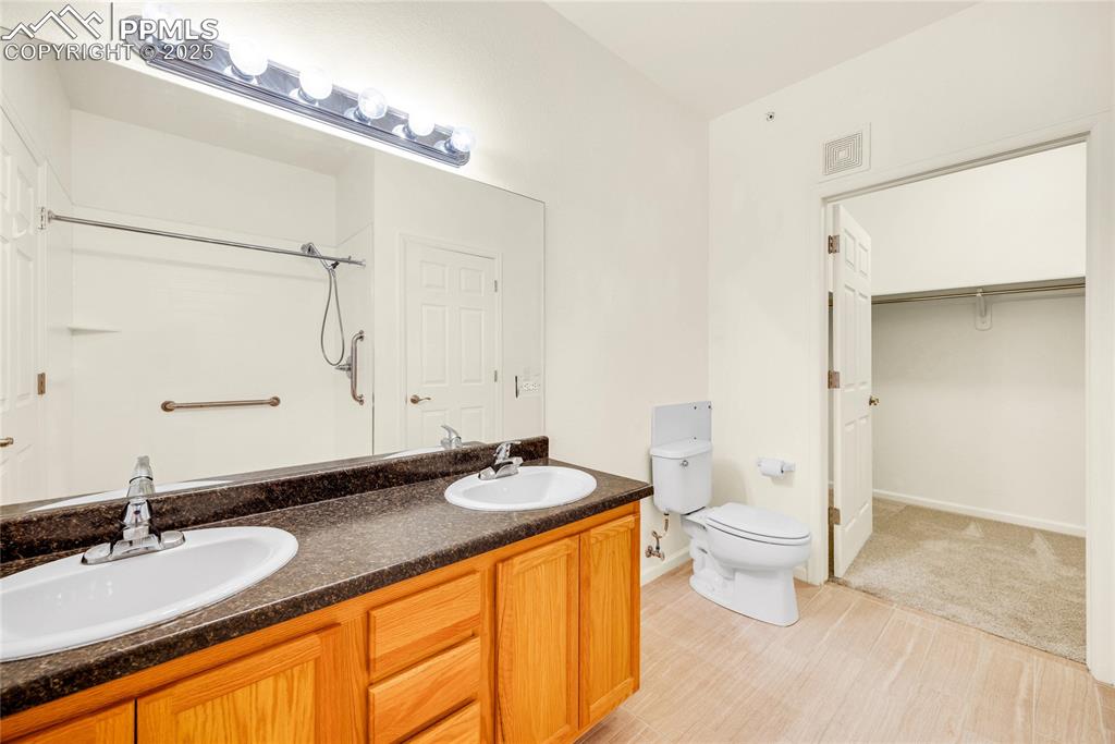 Image 9 of 37: Bathroom featuring double vanity, a shower, and a walk in closet